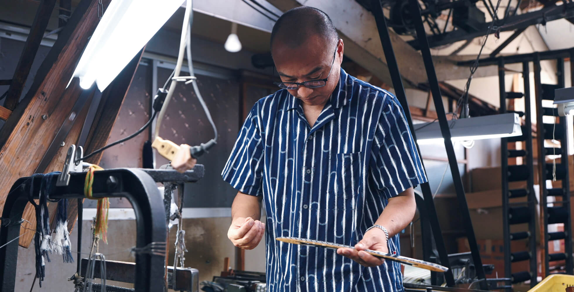 「触れることでしか研ぎ澄まされていかない」と、毎日織機に触れ、今も0.1ミリの感覚へ挑む下川さん