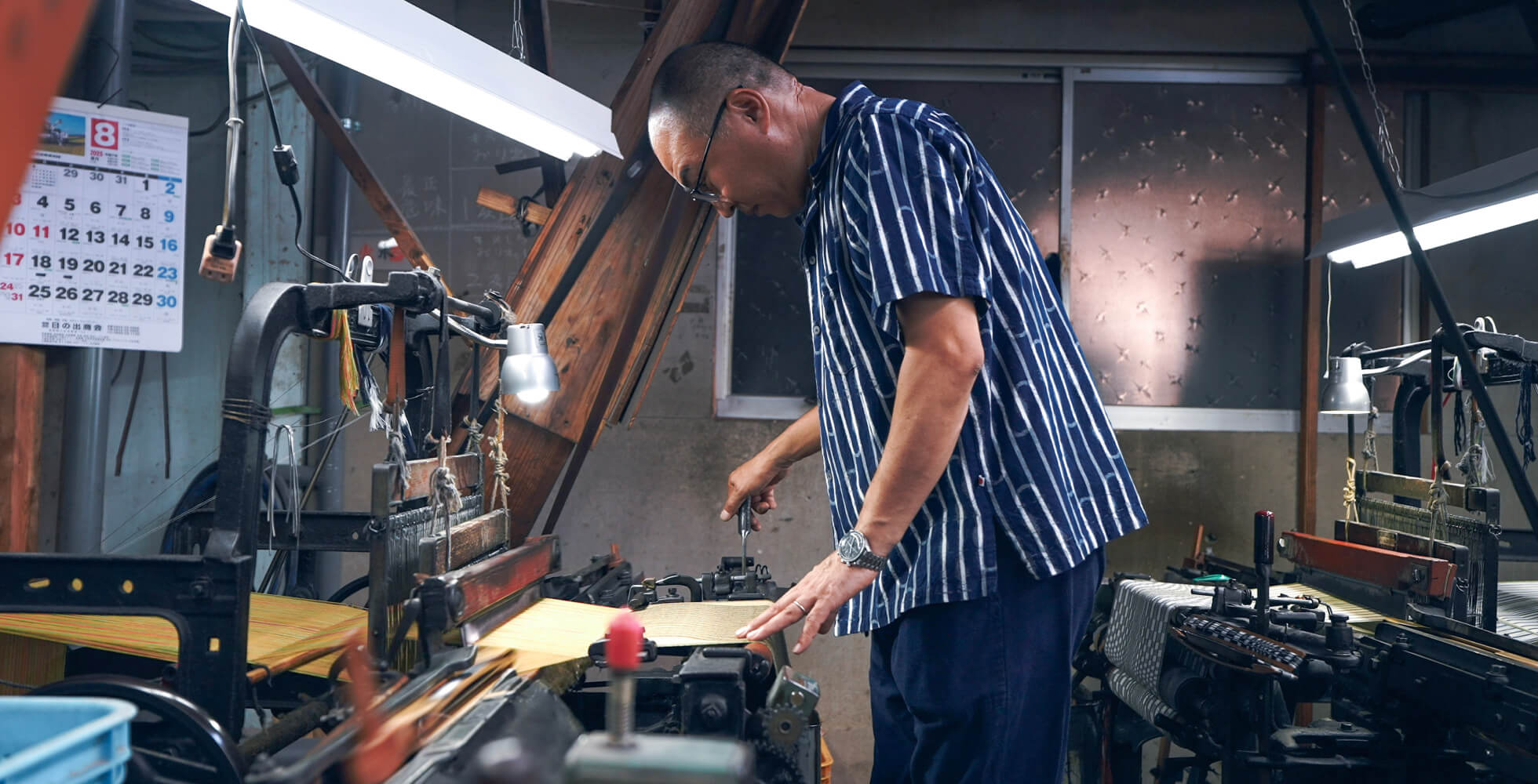 「触れることでしか研ぎ澄まされていかない」と、毎日織機に触れ、今も0.1ミリの感覚へ挑む下川さん