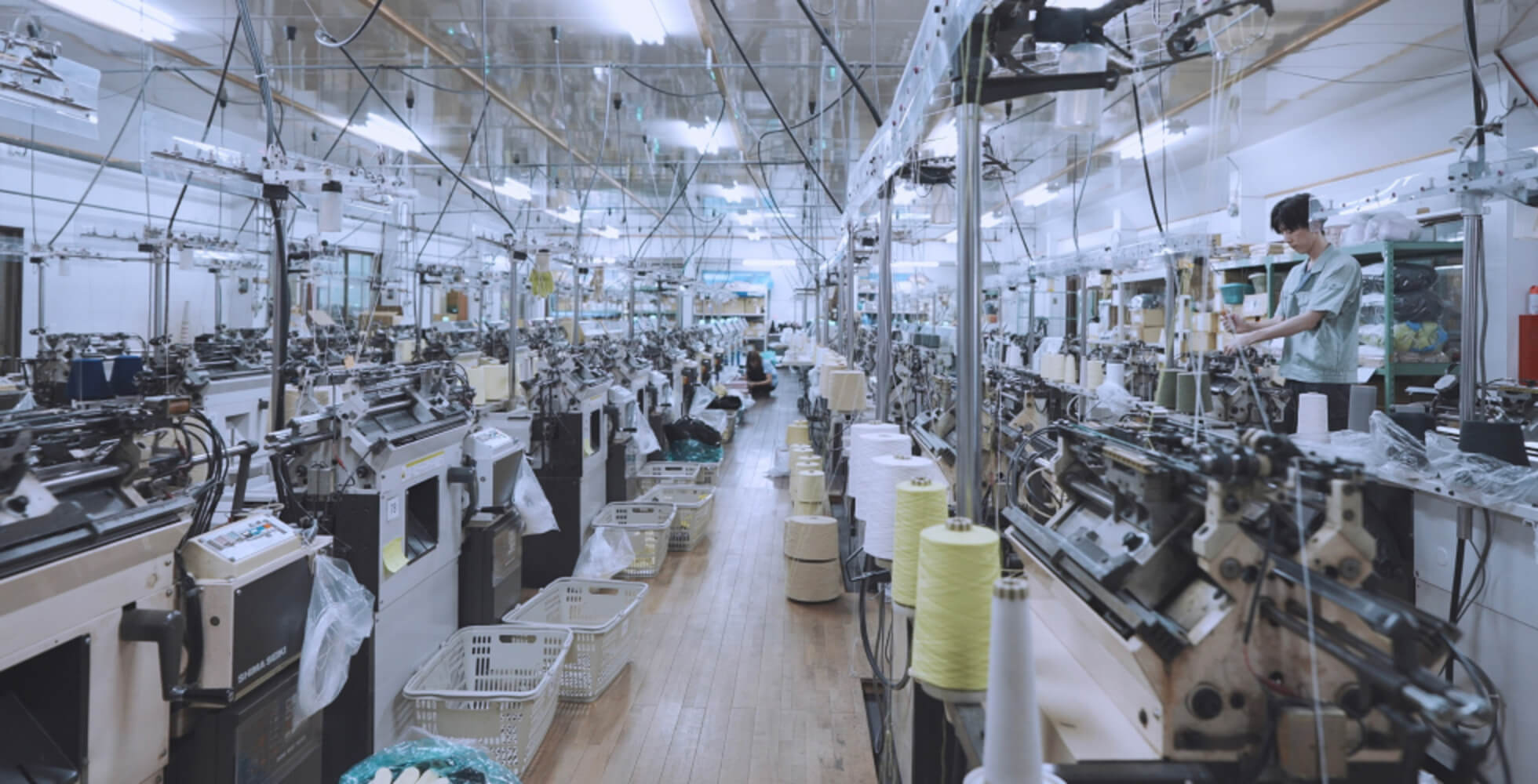 石川メリヤスの工場内。140台ほどの編み機が賑やかに稼働して、自動で製品を作る光景は壮観