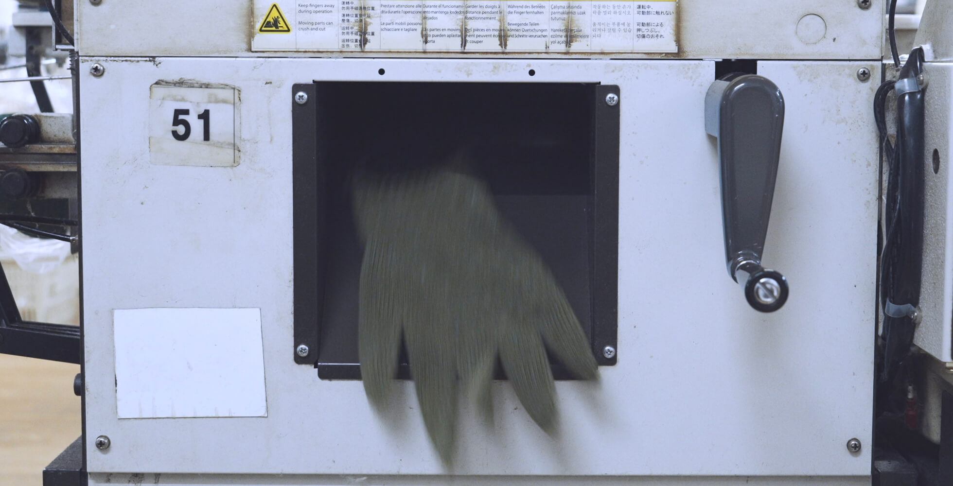 手袋の形まで編みあがると、自動販売機のようにスルンと機械下部から出てくる